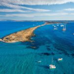 Veduta aerea delle acque turchesi tra Ibiza e Formentera con barche e velieri
