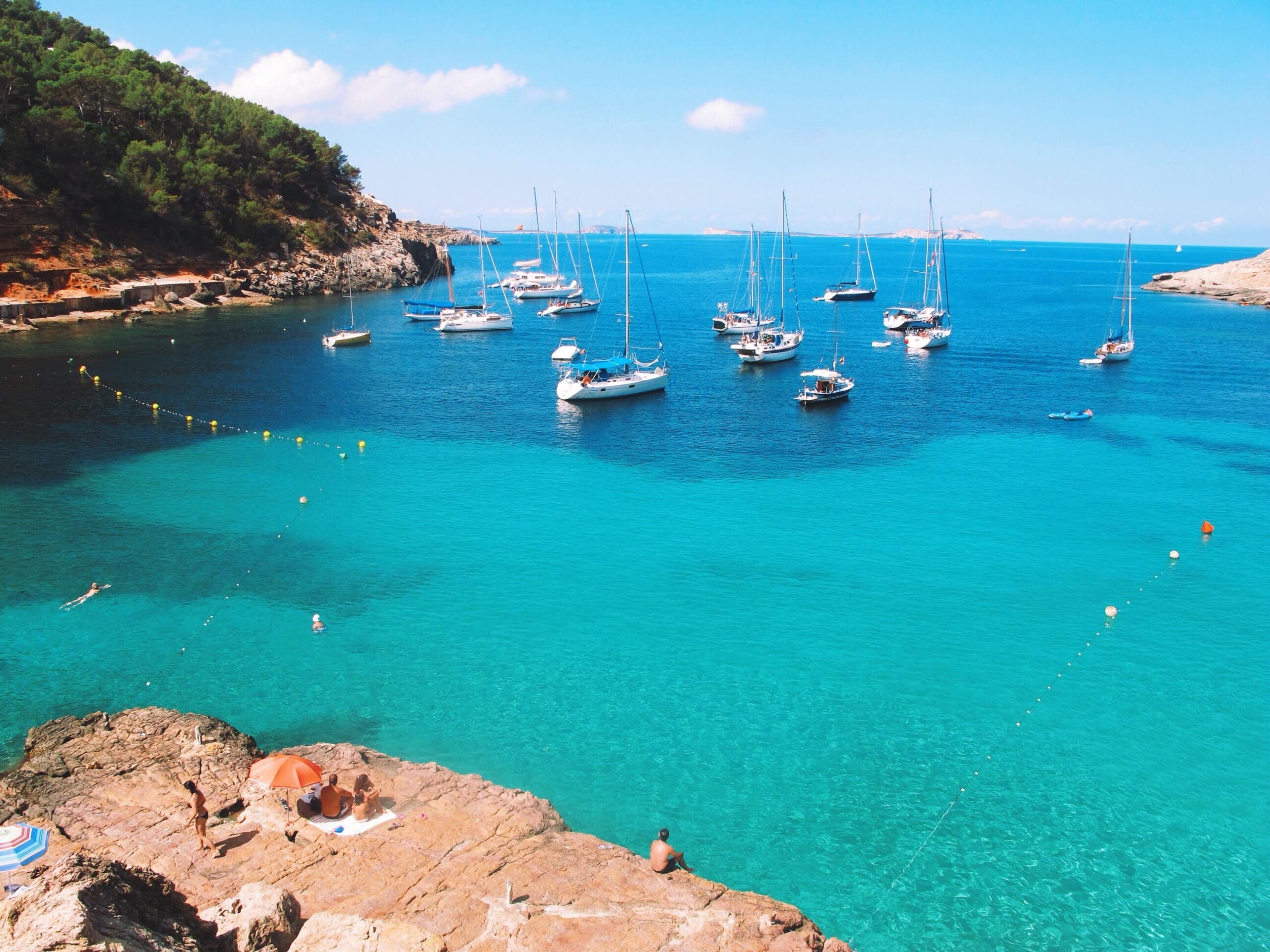 Barche a vela ancorate nelle acque turchesi di Cala Salada a Ibiza