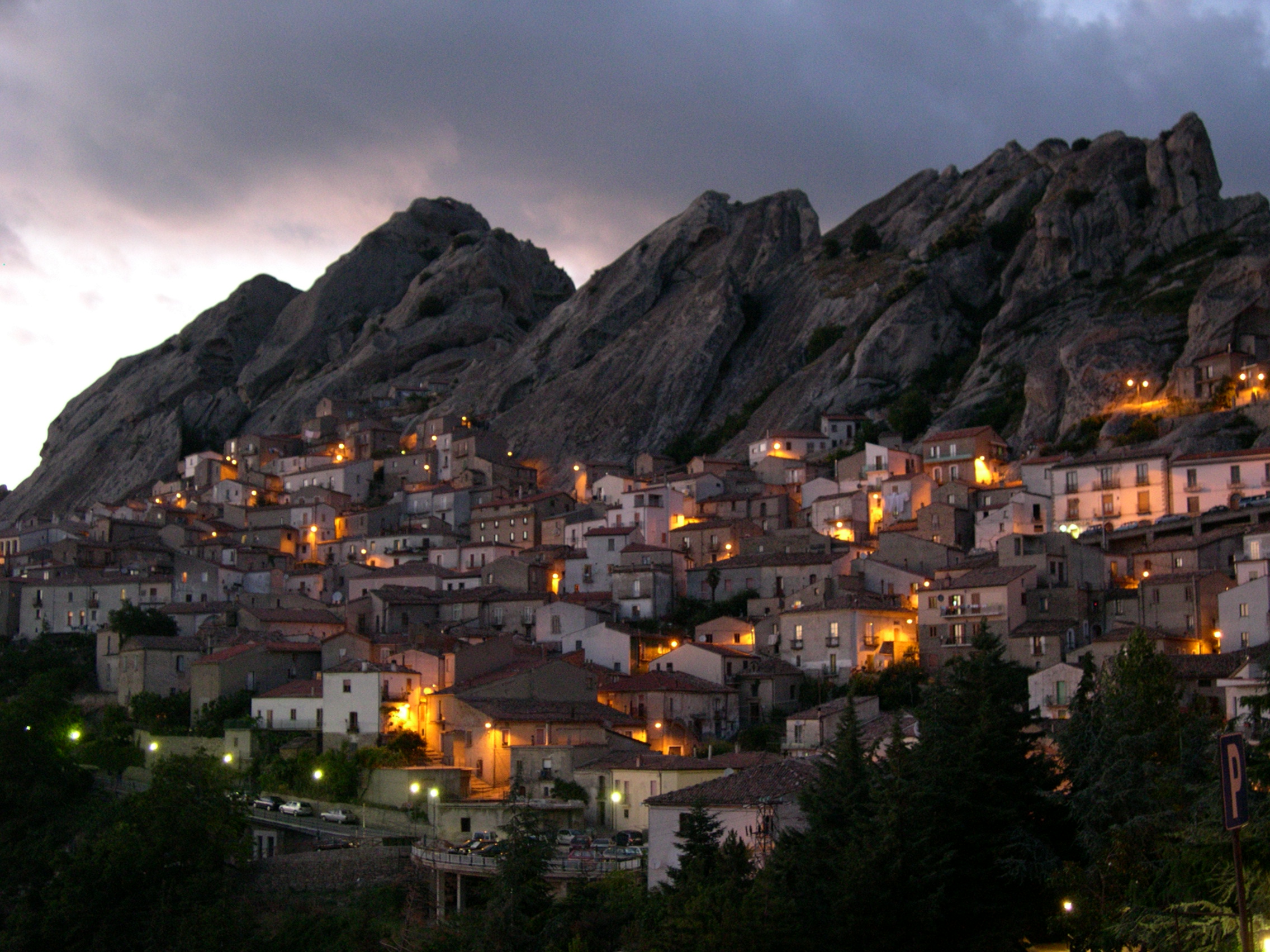 Borgo di Pietrapertosa illuminato al crepuscolo, con le case arroccate tra le rocce delle Dolomiti Lucane